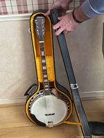 Banjo inside open hard shell case showing instrument placement and case interior