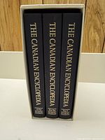 Three hardcover volumes of The Canadian Encyclopedia in slipcase with spines displayed: A-For, For-Pez, Pez-Z.