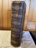 Spine of The Holy Bible showing embossed dark brown leather with gold gilt lettering and ornamentation