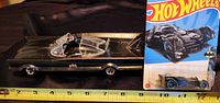 Side view of completed Batmobile model next to Hot Wheels Batmobile packaging with ruler showing scale