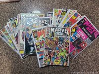 Collection of Marvel Age comics spread out on surface with several annual and preview issues visible.