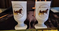 Pair of white milk glass mugs with colored Little Brown Jug Delaware Ohio racing logos on front