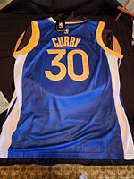 Back view of the jersey showing 'Curry' and number 30 in gold on blue fabric with white and gold trim.
