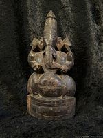 Front view of the hand carved wooden Ganesha statue showing detailed craftsmanship of the deity's face and intricate body carvings.