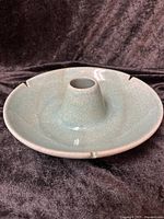 Full side view of round ashtray showing overall form and cigarette rests.