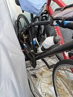 View of bicycle stand holding two bicycles, showing rear wheel and frame support with attached saddles and luggage rack.