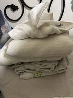 Folded white towels and linens stacked on top of each other, showing texture and layers