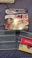 Photo shows two metal spice shelf racks and the boxed plastic swivel storage spice organizer.