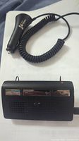 Black Motorola hands free car charger with coiled cord and cigarette lighter plug.