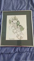 Full view of metal framed print artwork with child and ivy illustration, including 'Rosamond' title.
