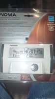 Front view of sealed NOMA programmable thermostat packaging showing device display and features