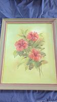 Full view of framed canvas showing floral art with pink hibiscus flowers and green leaves on light green background