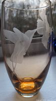 Clear image showing the etched hummingbird and hibiscus flower on the amber tinted crystal vase.