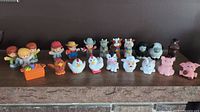 Vintage Fisher Price Little People group including farm children, farmer, and farm animals lined up on a shelf.