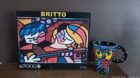 Box of the Romero Britto 2000-piece puzzle with colorful cartoon-style figures and 'BRITTO' text at the top.