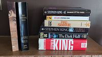 Nine books stacked with spines visible, including six Stephen King and two Anne Rice books.