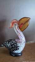 Full view of the vintage art glass pelican bird figurine showing the side profile and details of the body and beak.