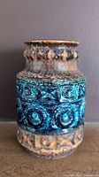 Front view of vintage Bay Keramik Fat Lava vase showing caramel and electric blue glazing with textured geometric pattern.