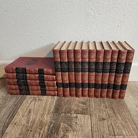 Showing 15 volumes of the encyclopedia arranged standing and stacked, some spines visible with black and gold labels.