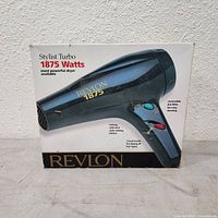 Front of original box showing Revlon Stylist Turbo hair dryer image and specifications including 1875 watts.