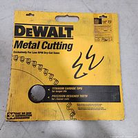 Dewalt branded yellow cardboard packaging for the metal cutting saw blade showing closeup of product features and branding.