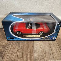 Side view of the boxed red 1/18 scale Ford Mustang Convertible diecast model.