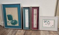 Wide photo showing all four framed Japanese art prints side by side on floor by wall.