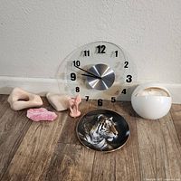 Photo showing the Aronie clock, rock pieces in beige and pink, a small deer figurine, and the Hamilton tiger plate