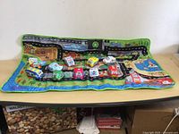 Top view showing Stuffie vehicles arranged on city-themed fabric play mat with roads and water areas