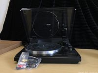 Pioneer turntable with transparent dust cover and placed cables in bag in front
