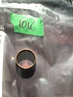 Ring in a plastic bag with green tape labeled “10K”