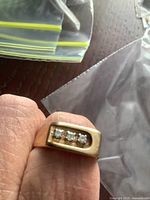 Front view of ring top showing three flush-set clear stones