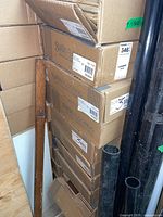 Stack of boxed hardwood flooring in basement, visible labels and box count