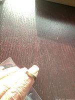 Ring held against dark wood surface, in plastic bag