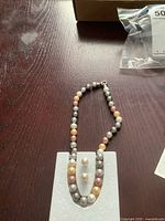 Necklace draped with matching earrings on foam display board