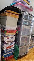 Stack of paper reams and green file pockets next to 5-drawer storage organizer