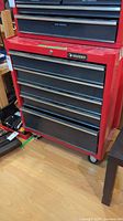 Front view showing entire red tool chest with Husky logo and caster wheels.