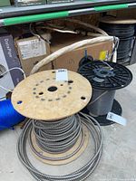 Assorted spools of conduit, cable, and rope on warehouse shelf