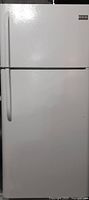 Front exterior view showing top freezer door and bottom refrigerator door in white finish