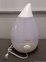 Crane ultrasonic humidifier unit showing teardrop design, front control knob, attached power cord.