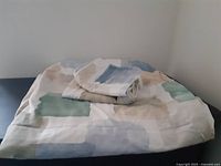 Full view of duvet cover and two shams folded on a surface showing pattern and texture.