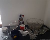 Wide view of all items in the lot including glass bowl, gravy boat, mugs, small glasses, and pitcher