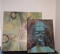 Two framed wall art pieces side by side, Buddha portrait and abstract art