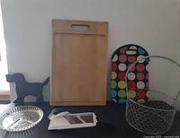 Photo showing all items together: wooden cutting board, dog leash hanger, mandoline slicer, glass dish, insulated bag, and mesh basket.