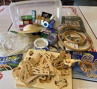 Overall lot of assorted crafting supplies including paints, wooden puzzle kits, embroidery hoops, ribbons, straw hats, and other accessories