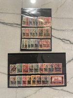 Top view of multiple vintage postage stamps from German offices in Morocco, displayed in plastic sleeves, showing various designs and cancellation marks.