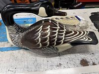 Front-side view of the hand-painted wooden Canada goose decoy on workbench.