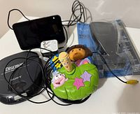 Sony Discman, kids electronic game toy with Dora the Explorer characters, and Amazon Echo Show device with attached power cable.
