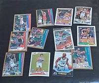 Image of 11 basketball cards laid flat showing front designs with players in various poses and uniforms.