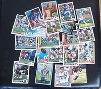 Photo showing a layout of 20+ vintage and recent football cards on black background.